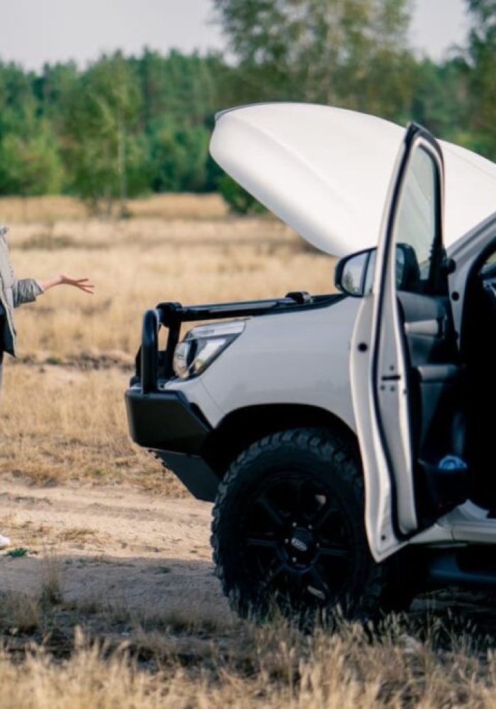 the-car-broke-down-on-road-in-forest-and-young-gir-QRUJQVX-1024x683